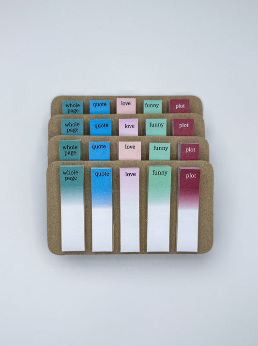 Set of colorful fiction sticky notes in a cardboard holder on a white background