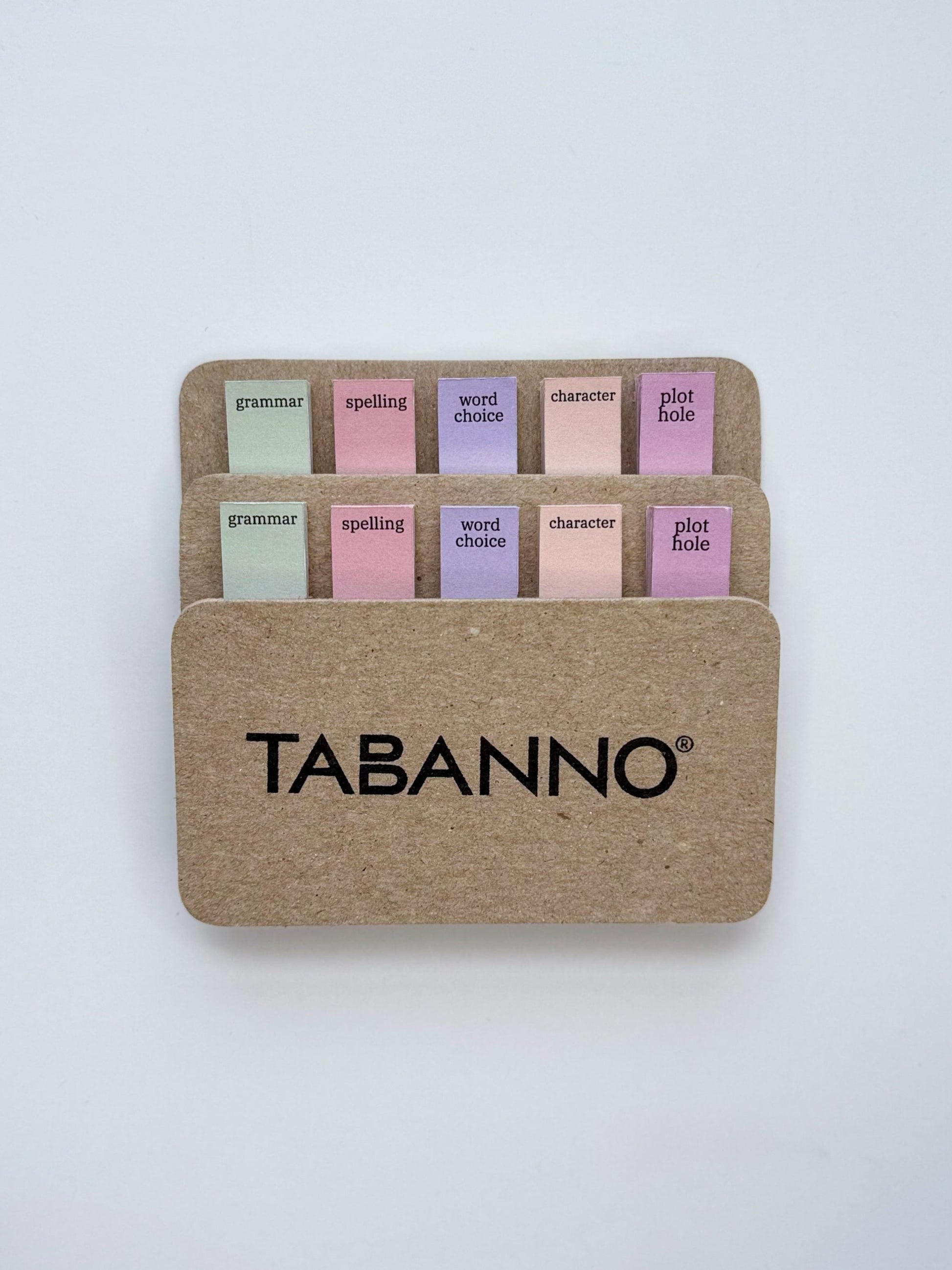 Set of colorful tabs in a cardboard holder with 'TABANNO' branding on a white background